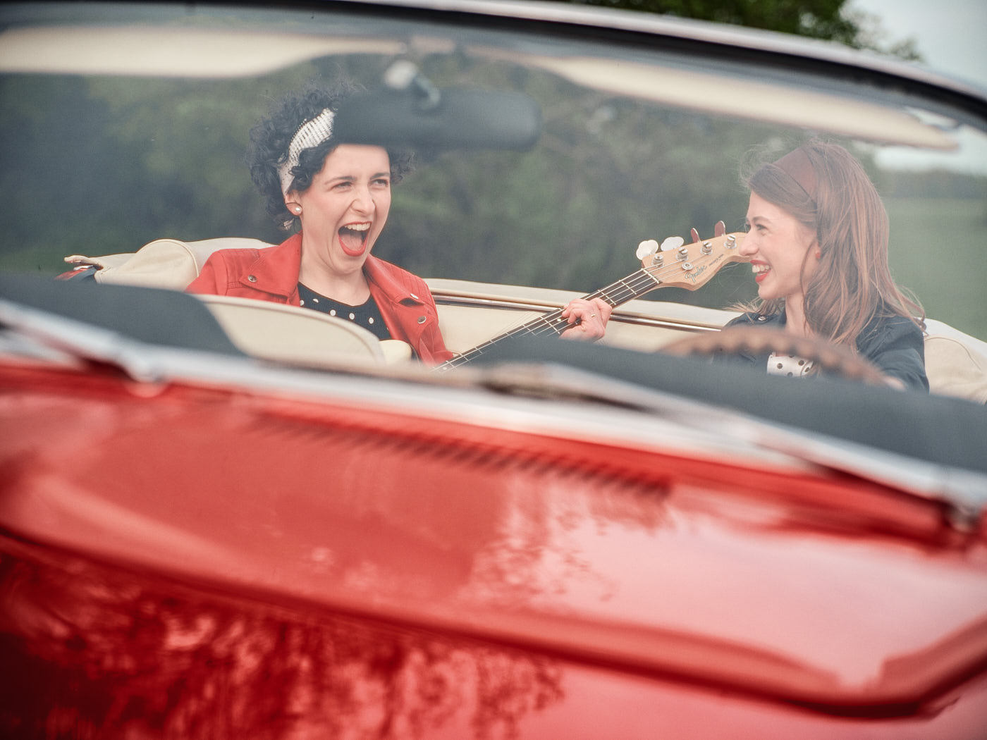 Smějící se 2 ženy v červeném mustangu - lifestyle portrét